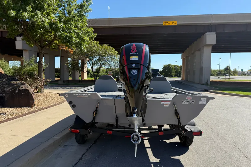 Slide: The Image of 2027 Tracker Pro Team 195 boat with powerful outboard motor parked under a bridge. - 16
