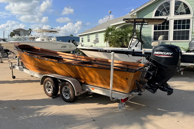 Slide: The Image of Homemade 2015 Jetdrive Skiff on trailer with Mercury outboard motor, parked outdoors. - 2