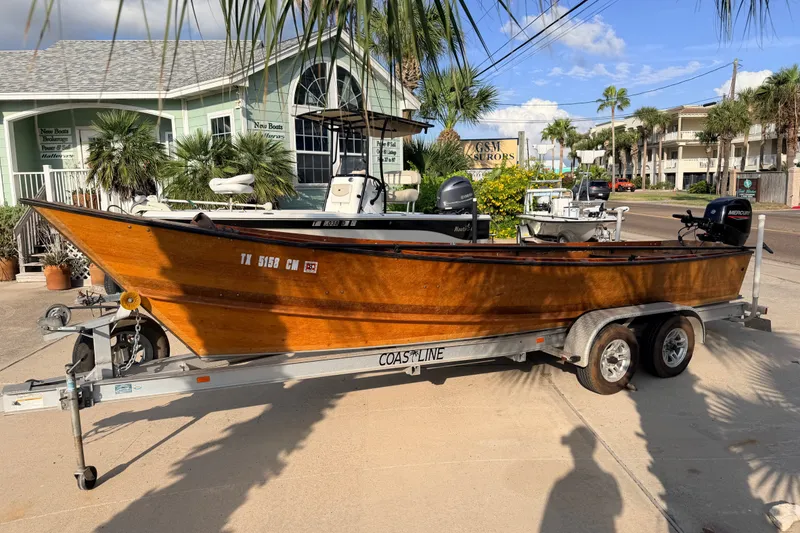 Slide: The Image of Wooden Homemade Jetdrive Skiff 2015 on trailer, parked near coastal buildings. - 1
