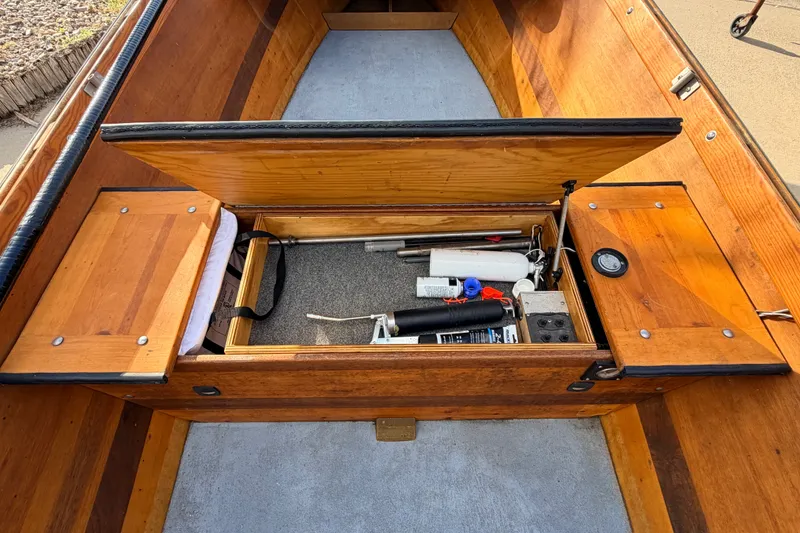 Slide: The Image of Open storage compartment in a 2015 Homemade Jetdrive Skiff, revealing tools and equipment. - 8