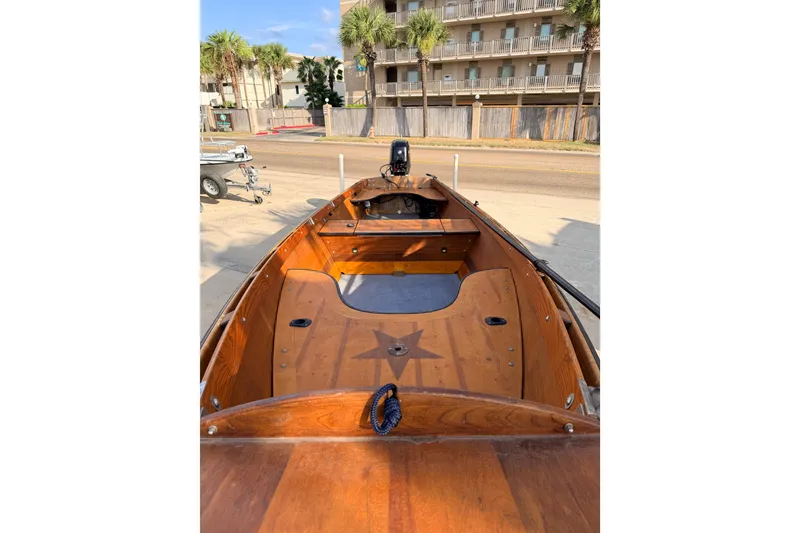 Slide: The Image of Wooden 2015 Homemade Jetdrive Skiff boat with star design, parked near a building. - 5