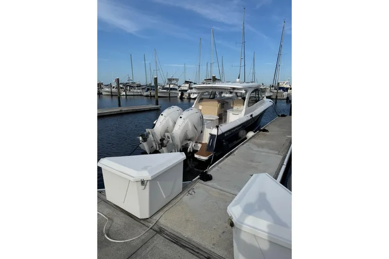 Slide: The Image of 2022 Southport 33 DC boat docked at marina with twin engines. - 33