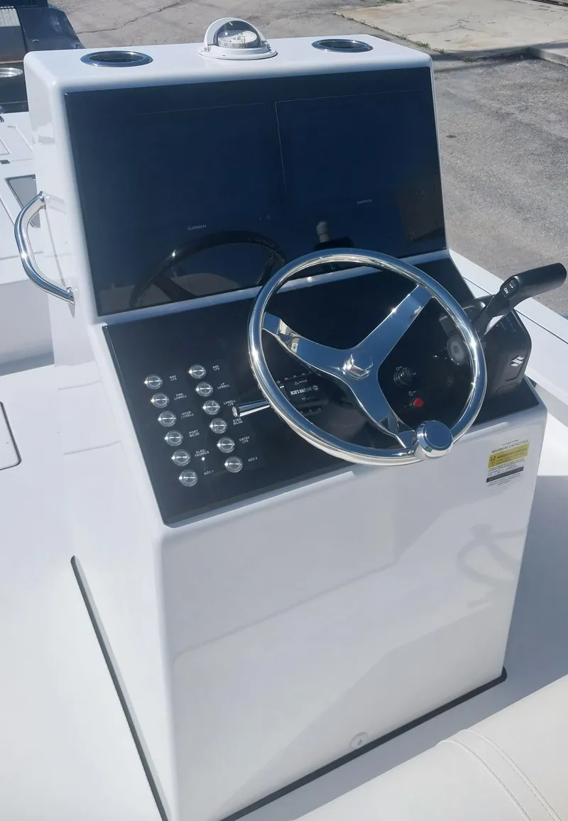 Slide: The Image of 2024 Savage Seas Shallow Bay SS22 boat console with steering wheel and control panel. - 17
