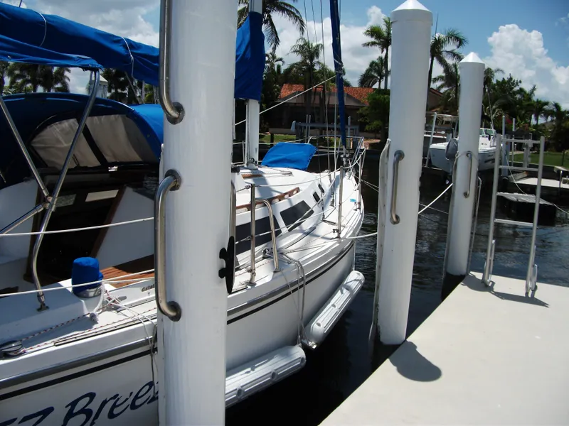 Slide: The Image of Catalina 30 MkII sailboat docked, 1992 model, with blue canopy and palm trees in background. - 29