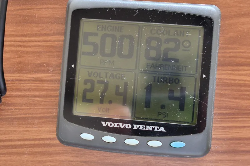 Slide: The Image of Volvo Penta engine display showing RPM, coolant temperature, voltage, and turbo PSI on wood surface. - 24
