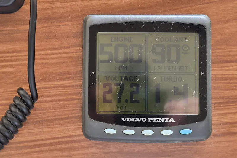 Slide: The Image of Volvo Penta engine display showing RPM, coolant temperature, voltage, and turbo PSI on wood surface. - 25