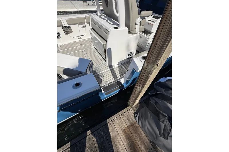 Slide: The Image of 2024 Sportsman Open 302 Center Console boat interior at dock, showcasing seating and deck layout. - 14