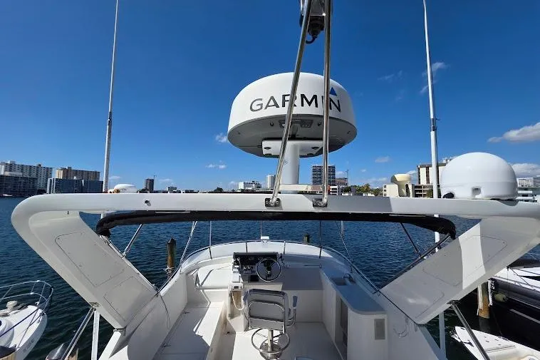 Slide: The Image of 1993 McKinna 48 Pilothouse yacht with Garmin radar, docked in a marina under clear blue skies. - 86