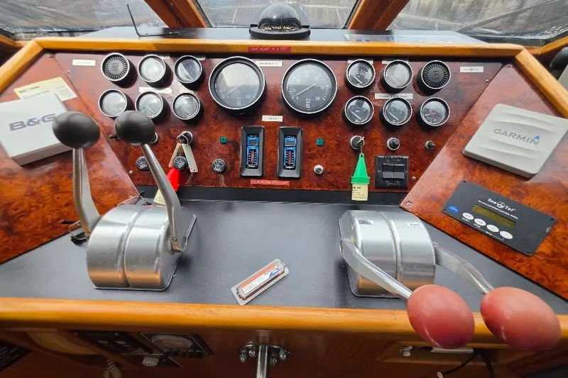 Slide: The Image of 1993 McKinna 48 Pilothouse dashboard with gauges, controls, and navigation equipment. - 142