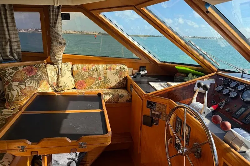Slide: The Image of Interior of 1993 McKinna 48 Pilothouse with floral seating and helm, overlooking the ocean. - 123