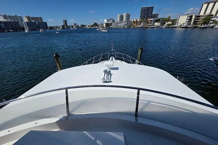 Slide: The Image of 1993 McKinna 48 Pilothouse yacht on calm waters with city skyline in background. - 81