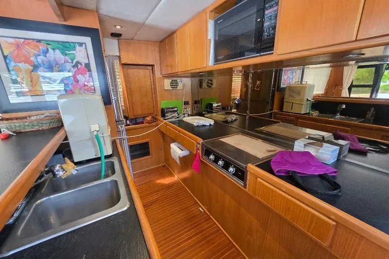 Slide: The Image of 1993 McKinna 48 Pilothouse yacht kitchen with wooden cabinetry and modern appliances. - 132