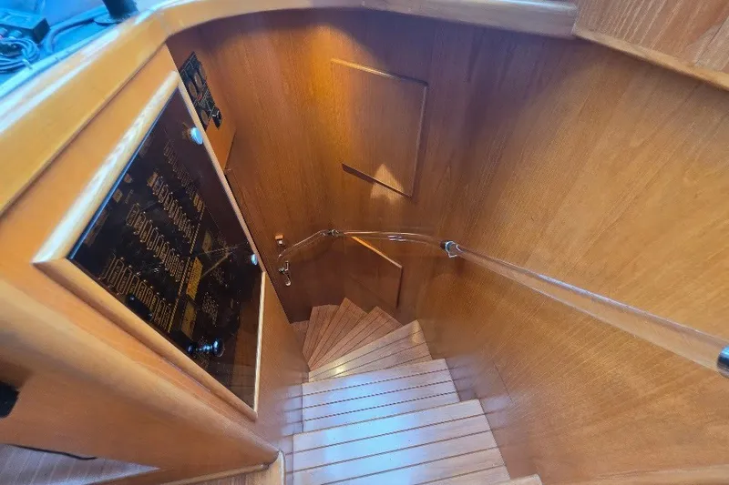 Slide: The Image of Staircase inside 1993 McKinna 48 Pilothouse yacht with wooden paneling and handrail. - 137