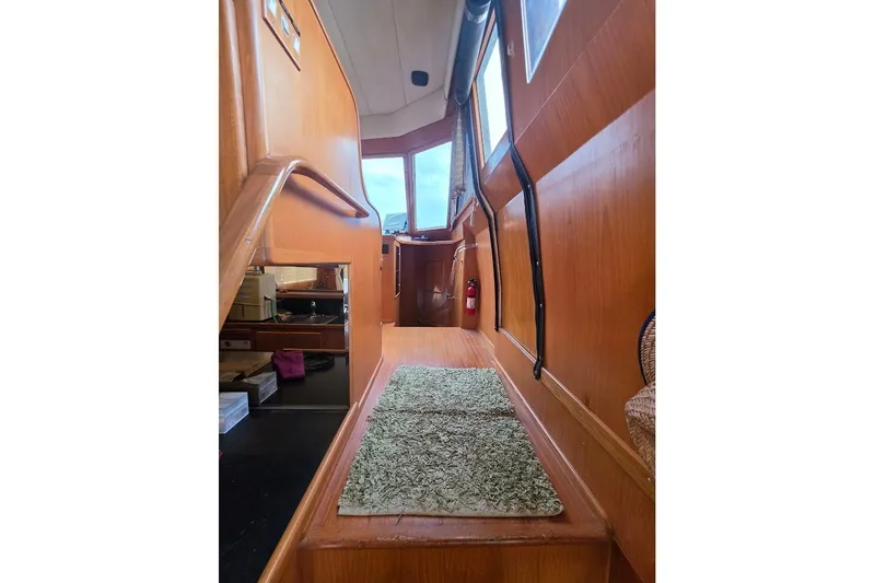 Slide: The Image of Interior view of 1993 McKinna 48 Pilothouse yacht with wooden finish and green carpet. - 134