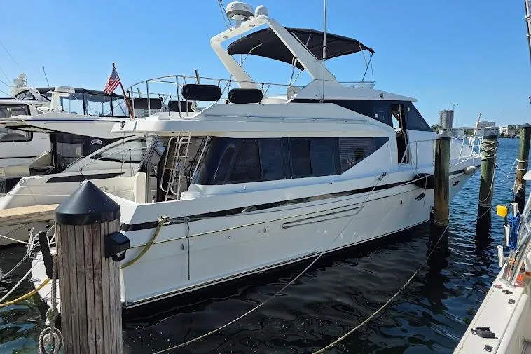 The Image of 1993 McKinna 48 Pilothouse yacht docked at marina under clear blue sky. - 0