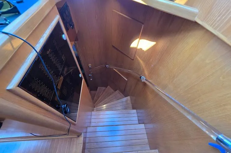 Slide: The Image of Staircase inside 1993 McKinna 48 Pilothouse yacht with wooden finish and sleek design. - 44