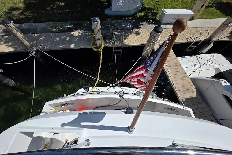 Slide: The Image of 1993 McKinna 48 Pilothouse yacht docked, displaying an American flag, viewed from above. - 88