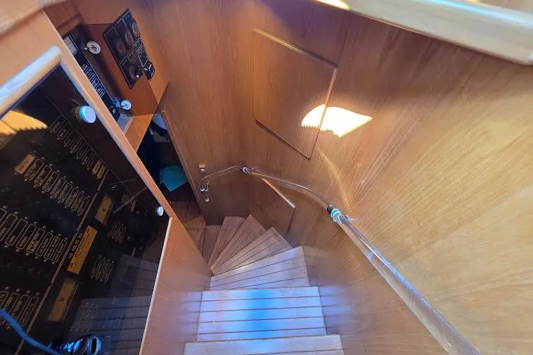 Slide: The Image of Staircase inside 1993 McKinna 48 Pilothouse yacht with wooden finish and control panel. - 45