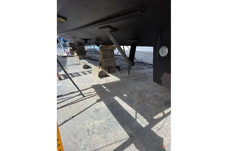 Slide: The Image of Underneath view of a 1993 McKinna 48 Pilothouse boat on dry dock. - 93