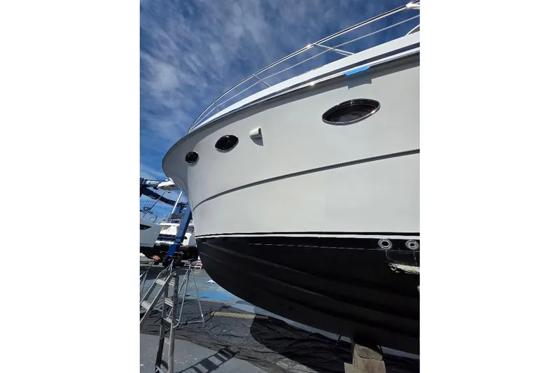 Slide: The Image of 1993 McKinna 48 Pilothouse yacht on dry dock under a clear blue sky. - 99
