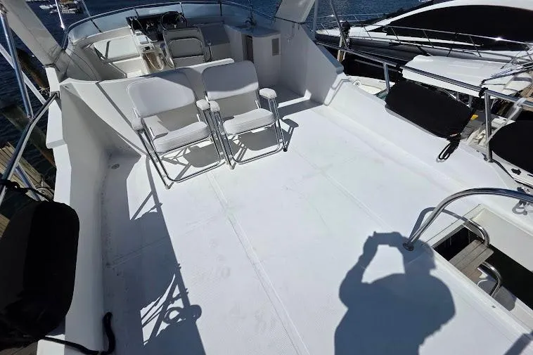 Slide: The Image of 1993 McKinna 48 Pilothouse yacht deck with seating and helm station. - 85