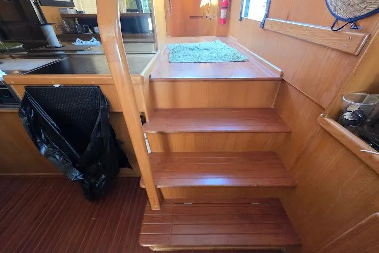 Slide: The Image of Interior stairs of 1993 McKinna 48 Pilothouse yacht with wooden finish. - 32