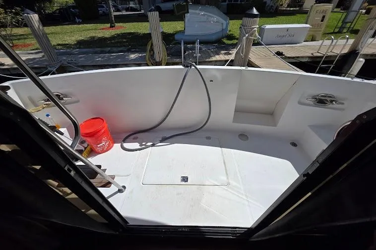 Slide: The Image of 1993 McKinna 48 Pilothouse boat deck with hose and red bucket, docked at marina. - 18