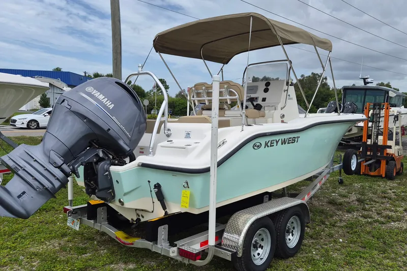 Slide: The Image of 2016 Key West 219 FS boat with Yamaha engine on trailer, parked outdoors. - 2