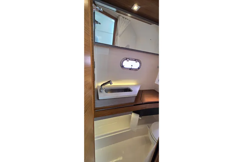 Slide: The Image of 2022 Tiara Yachts 34 LS bathroom interior with modern sink and porthole window. - 35