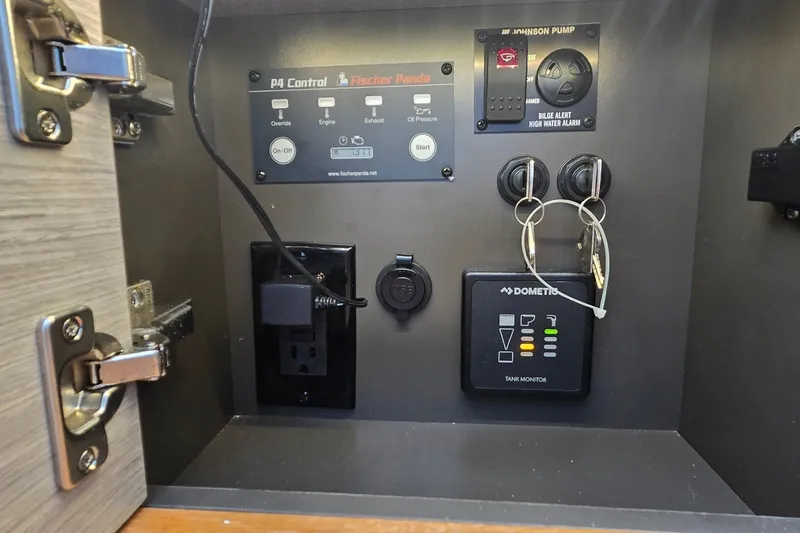 Slide: The Image of Control panel inside a 2022 Tiara Yachts 34 LS, featuring switches and a tank monitor. - 38