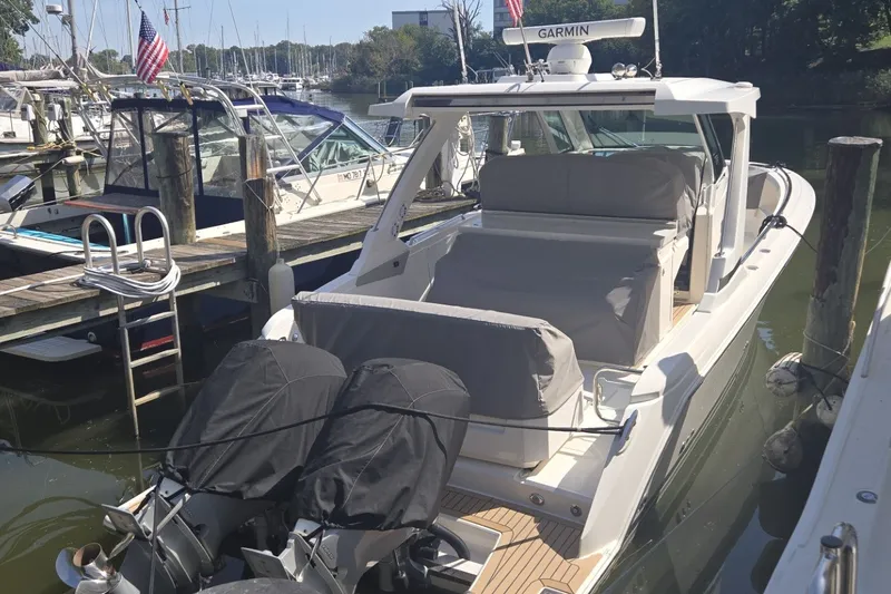 Slide: The Image of 2022 Tiara Yachts 34 LS docked, featuring covered seating and dual outboard engines. - 21