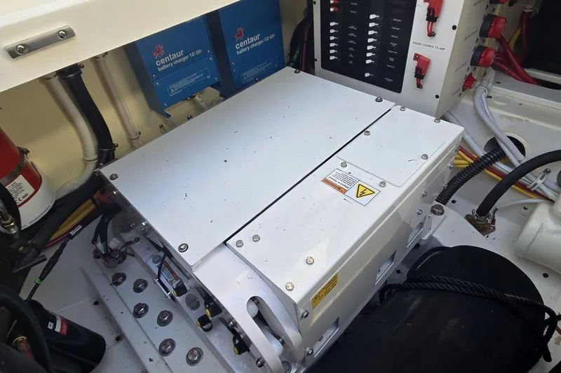 Slide: The Image of Engine compartment of 2022 Tiara Yachts 34 LS with battery chargers and control panel. - 28