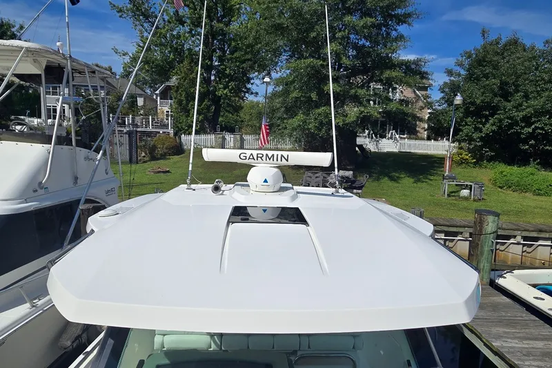 Slide: The Image of 2022 Tiara Yachts 34 LS with Garmin radar, docked near lush greenery. - 25