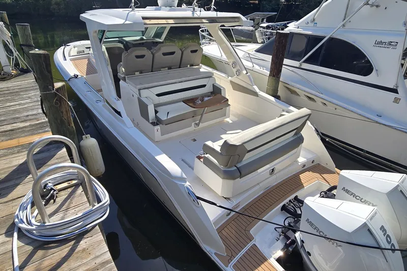 Slide: The Image of 2022 Tiara Yachts 34 LS docked, featuring spacious seating and twin Mercury engines. - 8