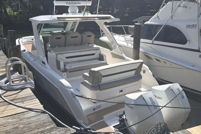 Slide: The Image of 2022 Tiara Yachts 34 LS docked, featuring spacious seating and twin Mercury engines. - 4