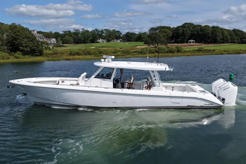 Slide: The Image of 2026 Everglades 455 Center Console boat cruising on a scenic waterway. - 12