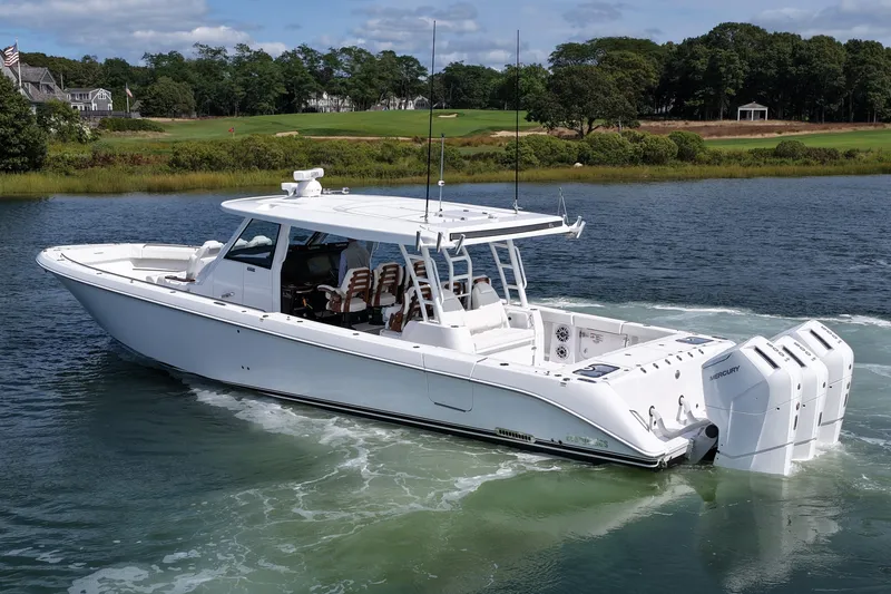 Slide: The Image of 2026 Everglades 455 Center Console boat cruising on a scenic waterway. - 11