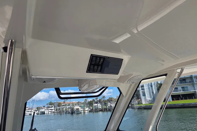 Slide: The Image of Interior view of 2019 Pursuit S 328 Sport boat with control panel and marina backdrop. - 32
