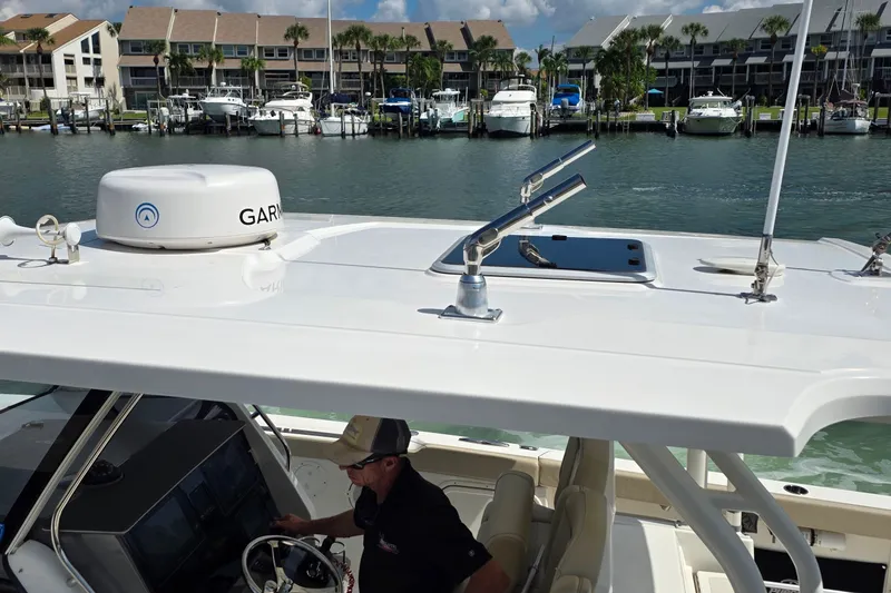 Slide: The Image of 2019 Pursuit S 328 Sport boat with Garmin equipment, docked near waterfront homes. - 23