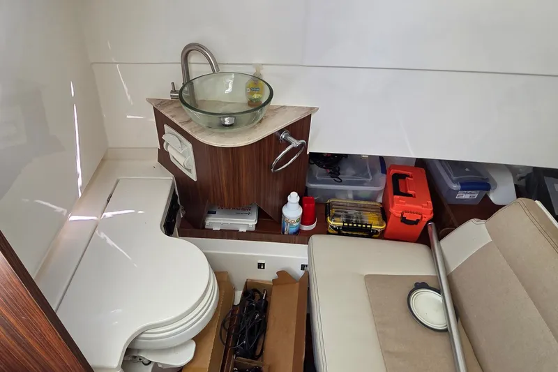 Slide: The Image of 2019 Pursuit S 328 Sport boat interior with sink, toilet, and storage compartments. - 42