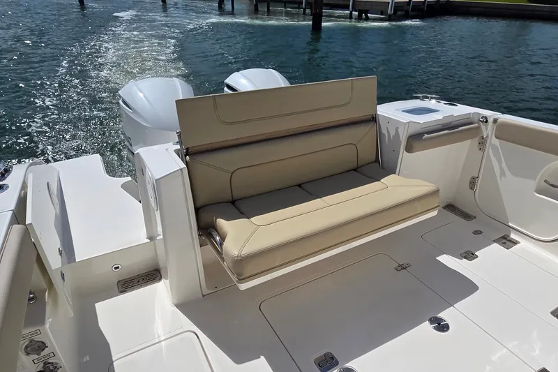 Slide: The Image of 2019 Pursuit S 328 Sport boat with beige seating and twin engines on water. - 26
