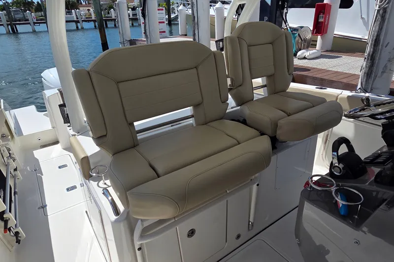 Slide: The Image of 2019 Pursuit S 328 Sport boat interior with beige cushioned seats and water view. - 30