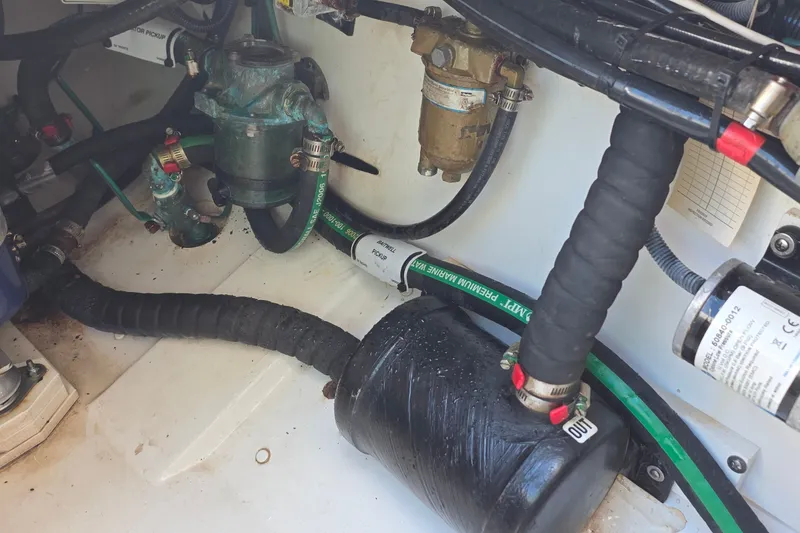 Slide: The Image of 2019 Pursuit S 328 Sport boat engine compartment with hoses and mechanical components. - 36