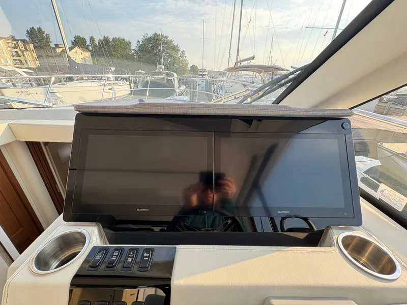Slide: The Image of The cockpit of the 2024 Regal 38 Grande Coupe with dual large Garmin screens and cup holders. - 22