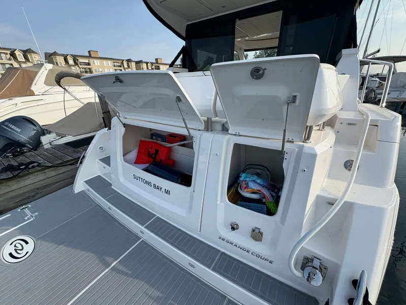 Slide: The Image of The 2024 Regal 38 Grande Coupe is docked. Open storage compartments reveal equipment and accessories. - 36