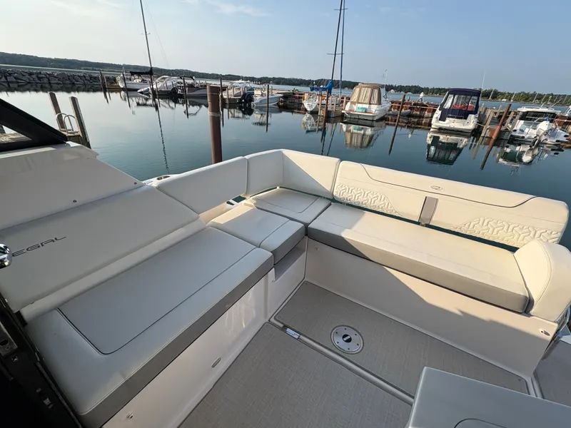 Slide: The Image of The 2024 Regal 38 Grande Coupe features a spacious, elegant seating area at the marina. - 28