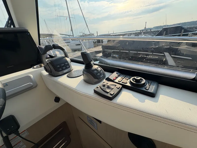 Slide: The Image of The cockpit of the 2024 Regal 38 Grande Coupe features modern controls and a view of the marina. - 24