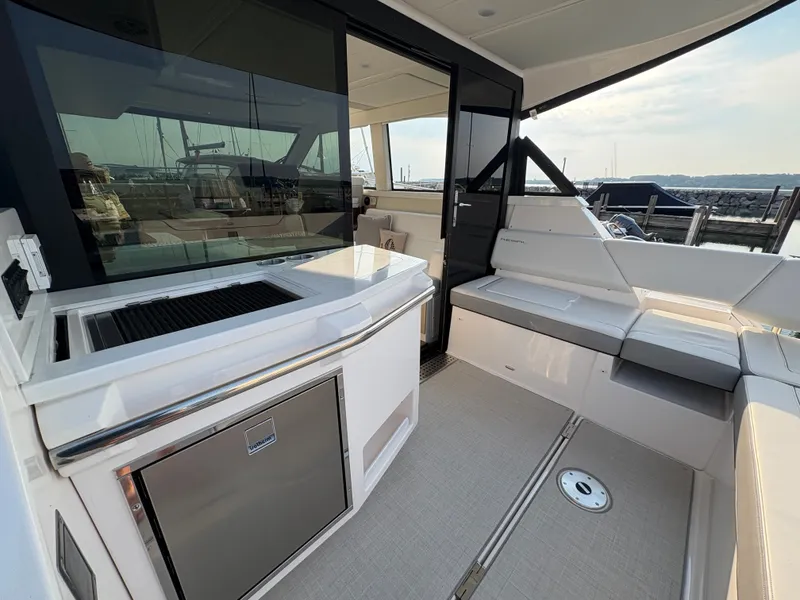Slide: The Image of The image shows the cockpit of a 2024 Regal 38 Grande Coupe with sleek seating and a small kitchenette. - 32