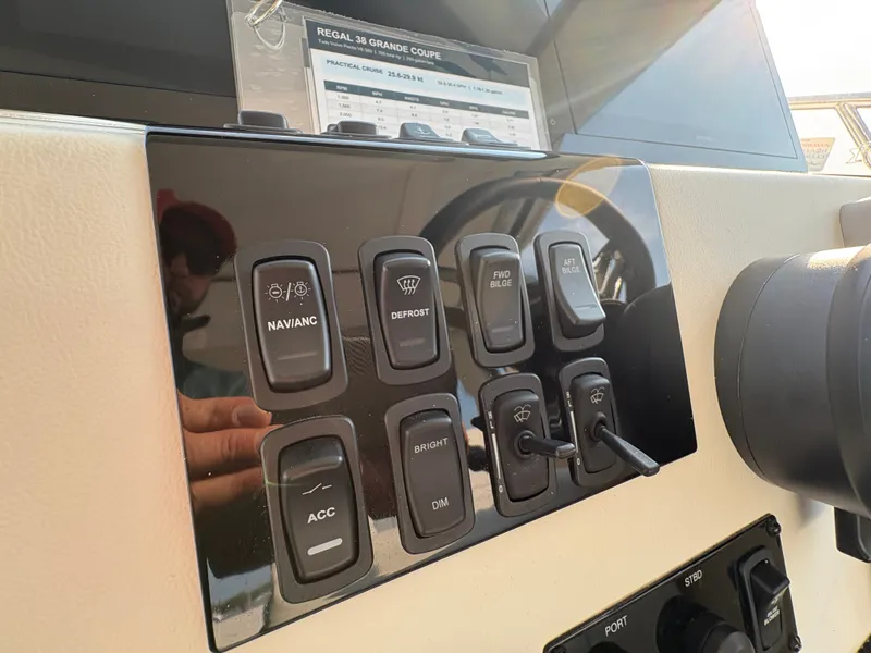 Slide: The Image of The dashboard of the 2024 Regal 38 Grande Coupe features various control switches and a display. - 20
