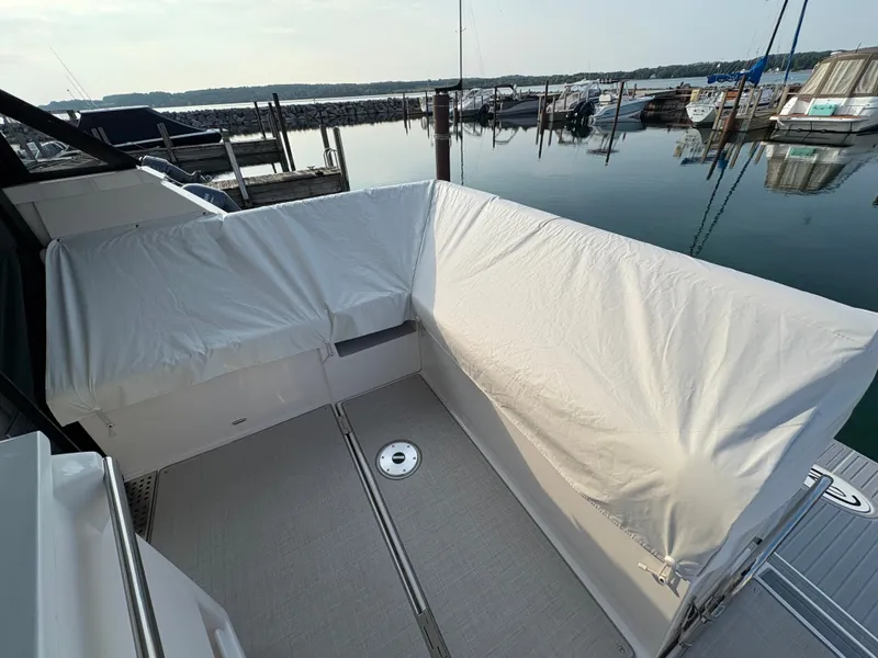 Slide: The Image of The image shows the stern of a 2024 Regal 38 Grande Coupe with a cover at the dock. - 39